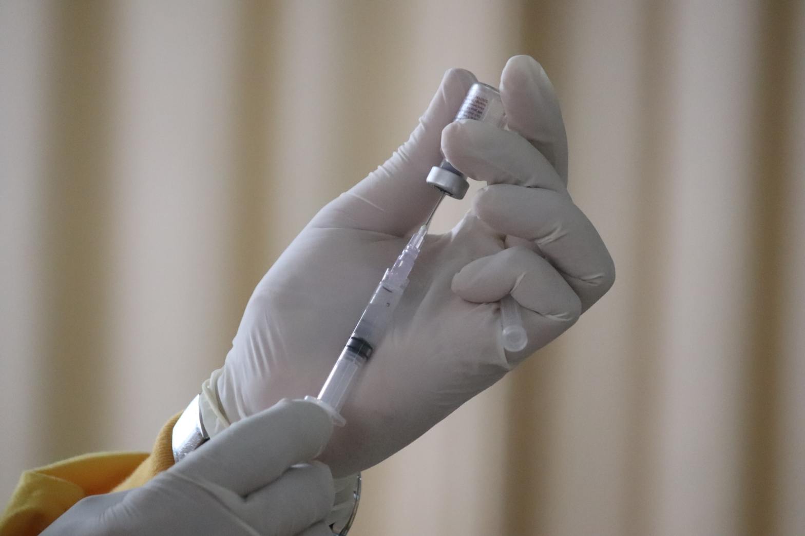 A person holding a syringe and a vial