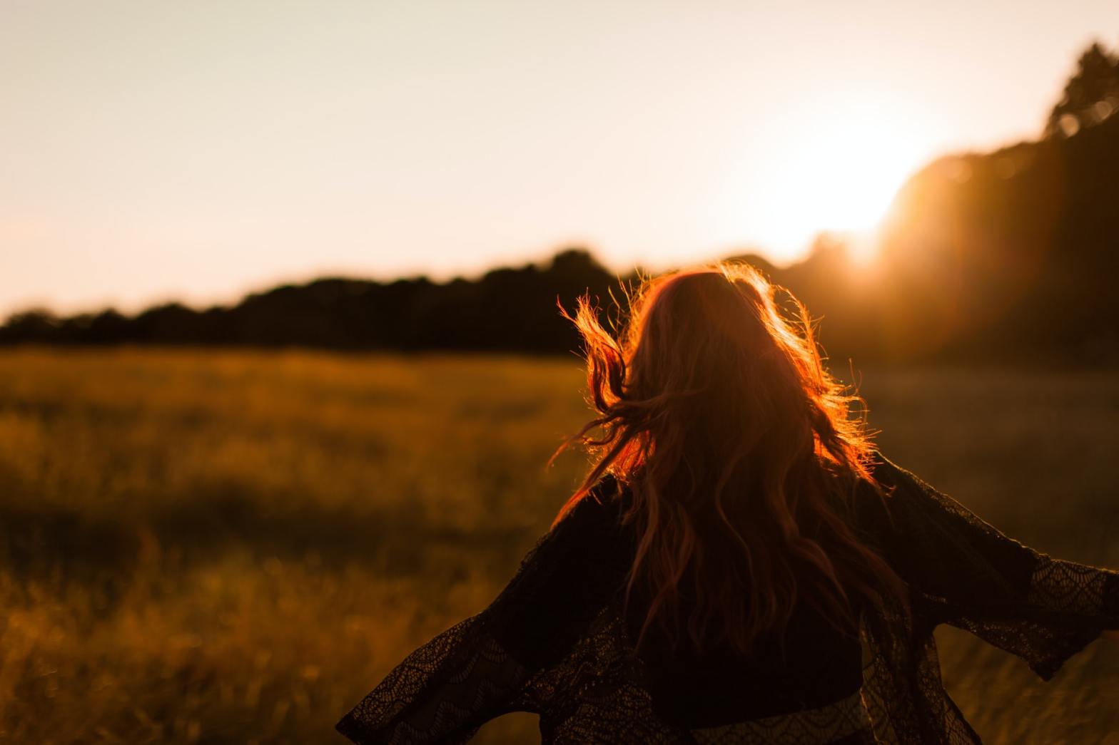 A girl in the field at sunset