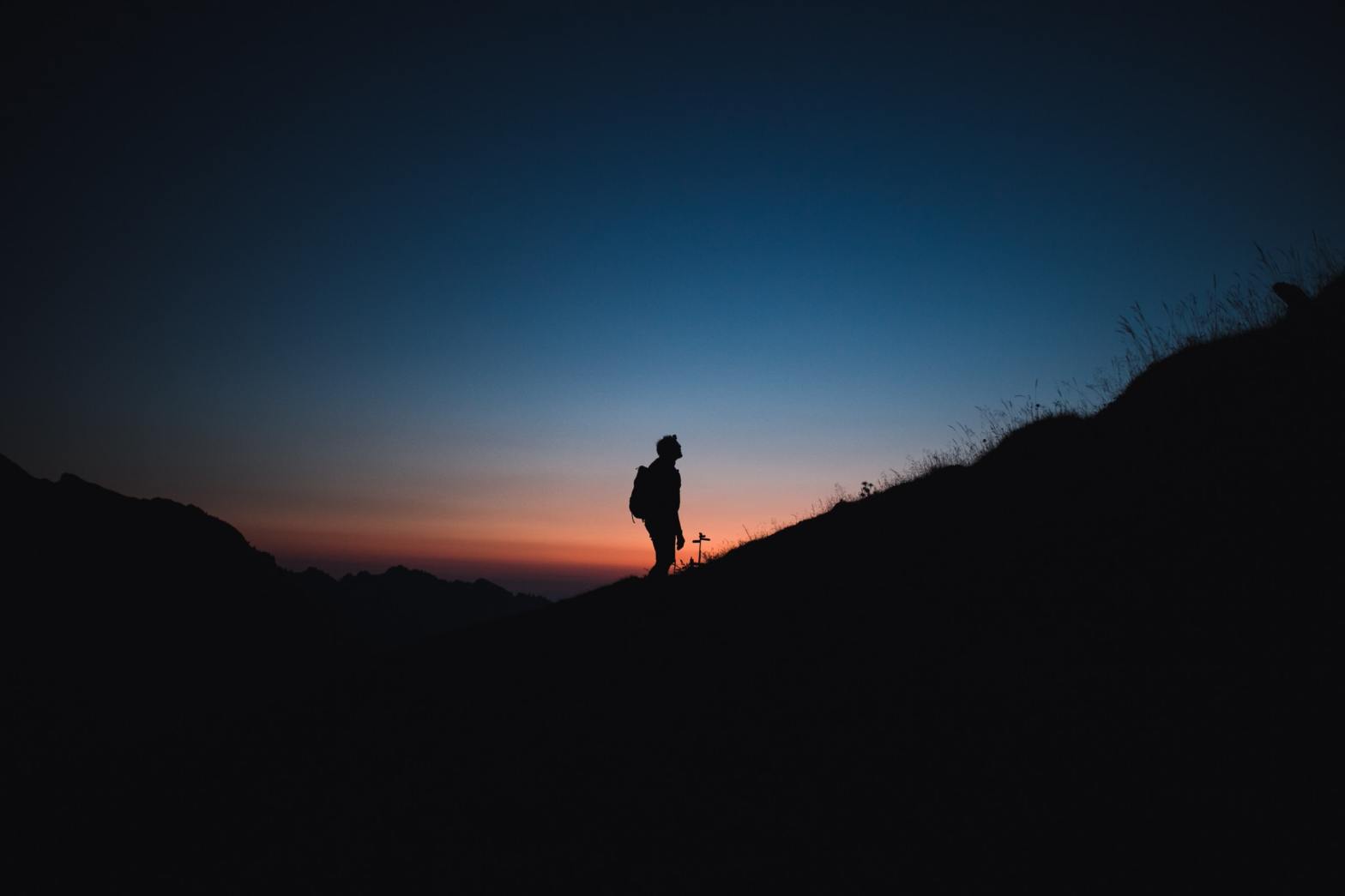 A silhouette of a person going uphill