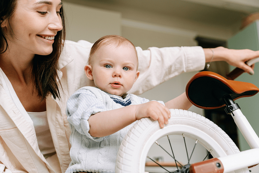 Smiling woman looking at her son near the bicycle.